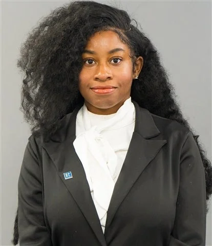 Portrait of Saniyyah Mushatt in a black blazer and white blouse